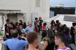 Grupo de pessoas no terraço do edifício Ialba-Luza, ao fundo, se vê placa fotovoltaica