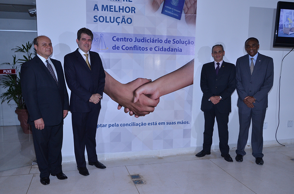 Os desembargadores Aldon Taglialegna e Paulo Pimenta, o juiz Israel Adourian e o vice-presidente da OAB/GO, Sebastião Macalé, ao lado de banner de identificação do Centro.