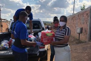 imagem mostra servidor do TRT entregando alimentos a família carente