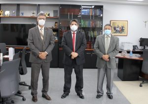 Foto colorida mostrando o ministro Caputo Bastos (ao centro) com o presidente do TRT-18, desembargador Daniel Viana Júnior (à esquerda), e com o vice-presidente do tribunal, desembargador Geraldo Rodrigues (à direita)