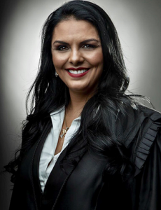 Mulher sorridente, de cabelos longos escuros e roupa preta