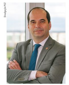 Ministro Alberto Bastos Balazeiro, calvo, de terno cinza e gravata azul de braços cruzados em close