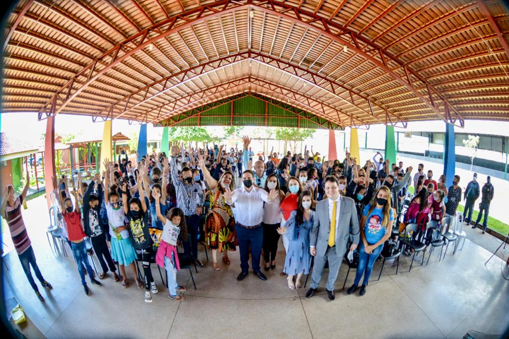 Foto de dezenas de alunos reunidos com professores, juízes e representantes de associações em um pátio de escola