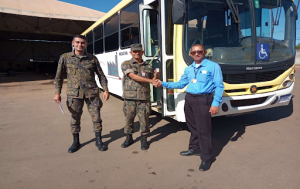 Representantes da base aérea de Anápolis recebendo o ônibus doado na ação trabalhista