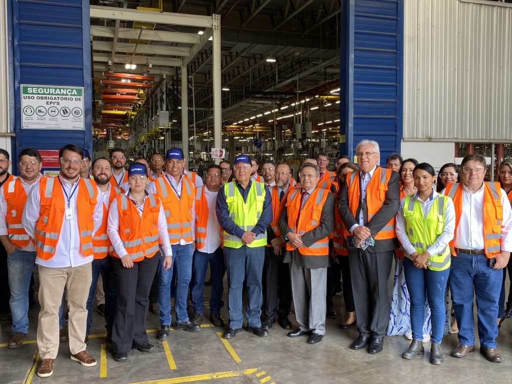 Grupo de funcionários, gestores e pessoas do TRT-18 e do MPT-GO com coletes de segurança laranja em pé.