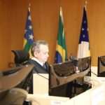Desembargador Geraldo Rodrigues Nascimento, durante sessão plenária. Ele está sentado em frente a uma mesa com computador e microfone