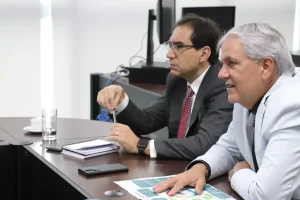 Foto colorida do desembargador Eugênio e do juiz Platon Neto sentados lado a lado e de perfil