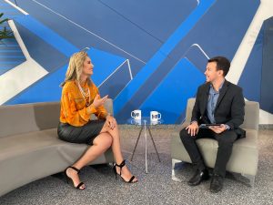 Estúdio do programa Hora Extra. Duas pessoas sentadas conversando, a entrevistada e o entrevistador