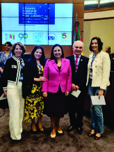 Cinco pessoas em pé, sendo um homem e quatro mulheres