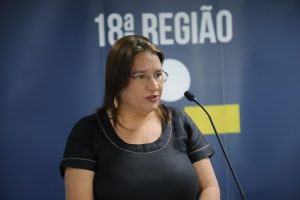 Mulher em pé falando ao microfone