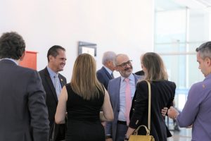 Foto de público circulando pelo salão durante evento.