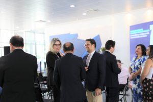 Foto de público circulando pelo salão durante evento.