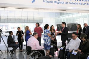 Foto de público circulando pelo salão durante evento.