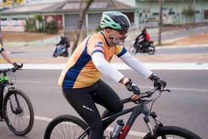 Foto mostra homem branco com barba pedalando