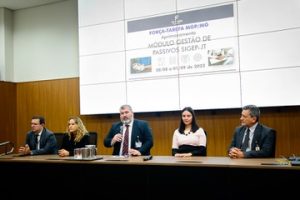 5 pessoas sentadas em mesa no palco para apresentação do projeto