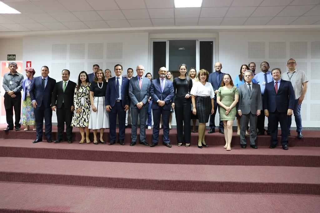 Foto de magistrados, juízes e advogados presentes na reunião. Na imagem, um grupo de pessoas constituído por homens e mulheres se posicionam lado a lado em duas filas, de pé, posando para a foto. 