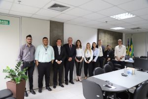 Foto de 7 Homens e 3 mulheres lado a lado posando para uma foto em um ambiente de uma sala bem iluminada