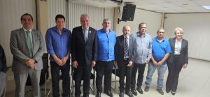 Foto mostra 7 homens e 1 mulher, eles estão lado a lado em pé