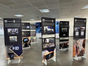 Foto colorida da exposição "Episódio 500". Trata-se de sete painéis contendo acontecimentos marcantes da Justiça do Trabalho de Goiás. Cada painel contém informações em forma de texto e imagens.