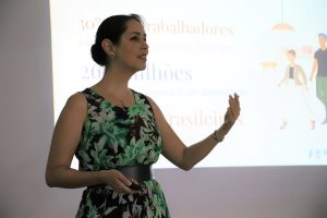 Psicóloga Marina Cançado. Trata-se de uma mulher branca, de cabelos escuros presos em um coque. Ela usa um vestido verde com um cinto preto na cintura.