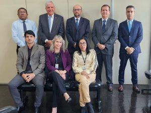Foto colorida do corregedor com a equipe da 1ª VT de Anápolis. Tratam-se de oito pessoas, sendo cinco homens de pé ao fundo, e um homem e duas mulheres sentados à frente.