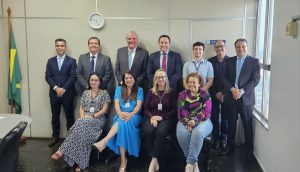 Foto colorida do corregedor com a equipe da 2ª VT de Anápolis. Tratam-se de onze pessoas, sendo sete homens de pé ao fundo e quatro mulheres sentadas à frente.