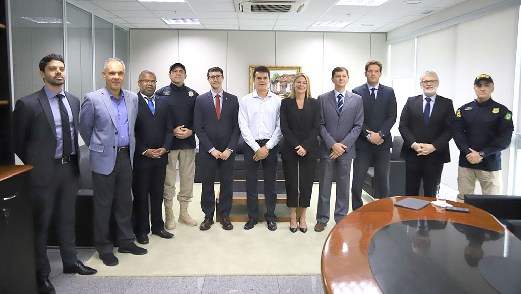 Grupo de pessoas em pé numa sala fechada