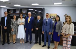 Foto mostra oito pessoas em pé, lado a lado, posando para a foto. Entre elas estão desembargadores e servidores do TRT-18 e representantes da PGE-GO