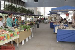 Foto colorida mostra uma feira realizada no TRT, com barracas de artesanato e alimentos