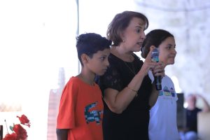 Foto da desembargadora do TRT-18, Kathia Bomtempo no meio de duas crianças.