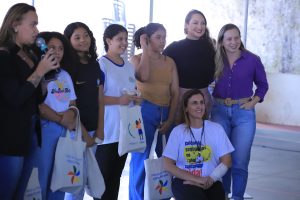 Foto de autoridades e estudantes segurando uma sacola de pano que foi um kit sorteado