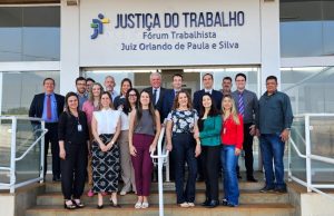 Foto de um grupo de pessoas em frente ao prédio do Fórum Trabalhista Juiz Orlando de Paula e Silva da Justiça do Trabalho.