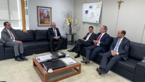 cinco homens sentados em sofás conversam