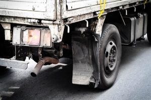 imagem mostra parte traseira de um caminhão parado em uma rodovia