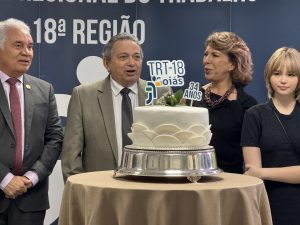 Quatro pessoas ao redor de um bolo em comemoração ao aniversário de instalação do TRT-GO