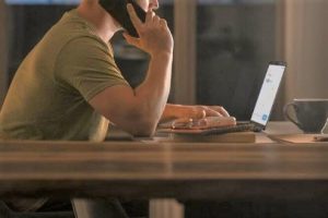 imagem mostra parte de uma pessoa trabalhando com notebook