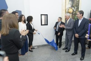 pessoas descerram placa de inauguração