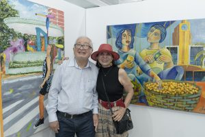 Duas pessoas em frente a duas pinturas