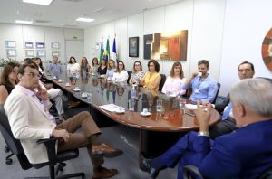 A imagem mostra o presidente do TRT-GO e os servidores sentados ao redor de uma mesa no Gabinete da Presidência