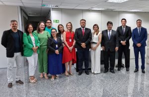 Grupo de pessoas vestidas formalmente alinhadas lado a lado posando para uma foto