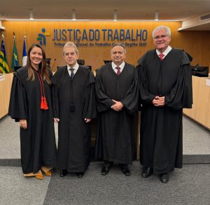 Quatro pessoas em pé posando para foto em ambiente fechado