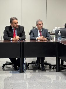 Dois homens usando terno sentados em uma mesa