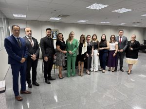 Grupo de pessoas vestidas formalmente alinhadas lado a lado posando para uma foto