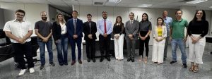 Grupo de pessoas vestidas formalmente alinhadas lado a lado posando para uma foto