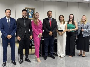 Grupo de pessoas vestidas formalmente alinhadas lado a lado posando para uma foto