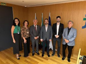 Seis pessoas estão reunidos para uma fotografia em grupo em um espaço cerimonial do TRT-GO. Eles estão lado a lado, olhando para a câmera.