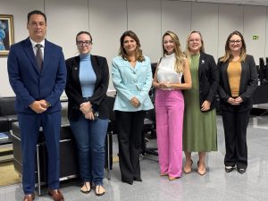 Fotografia de grupo com treze pessoas em volta de uma mesa posta. Algumas pessoas estão em pé e outras sentadas.