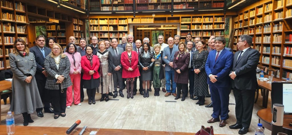 Foto mostra participantes do Coleprecor em pé, lado a lado, posando para foto em uma biblioteca