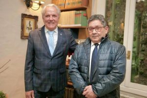 Desembargador Eugênio Cesário e desembargador Jorge Guedes em pé, lado a lado posando para foto. Ao fundo, livros em uma estante e um quadro na parede.