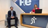 Um homem sentado em uma poltrona e uma mulher numa bancada. Eles olham para a câmara. Ao fundo, a logomarca do programa hora extra. Embaixo da bancada, a logomarca da Justiça do Trabalho